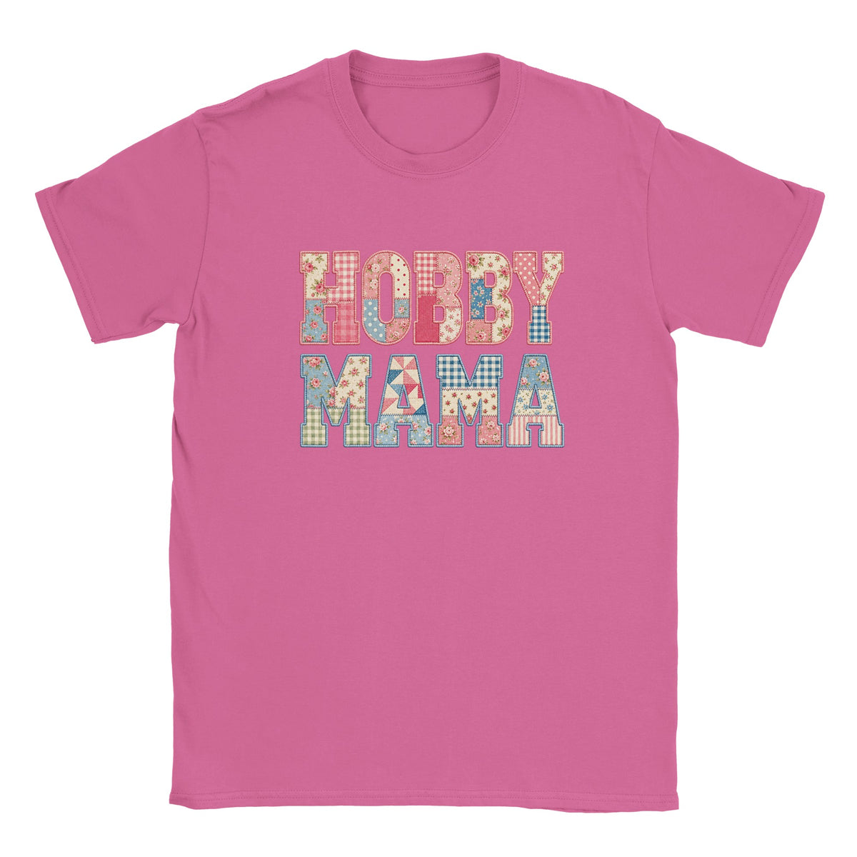 A pink short-sleeve crewneck t-shirt featuring a colorful graphic text print that reads 'HOBBY MAMA' in a patchwork pattern of various small colored squares and floral motifs.